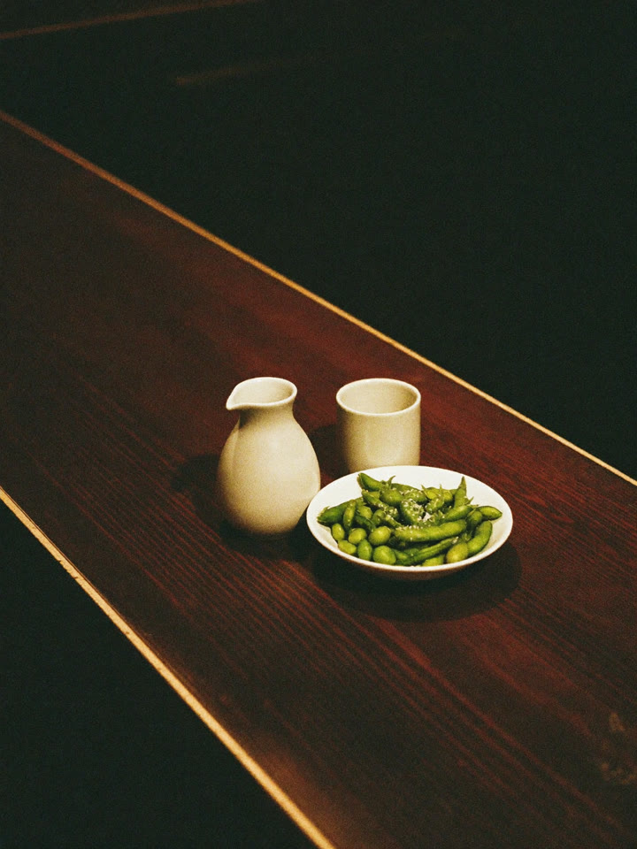 Sake carafe and edamame on a bar